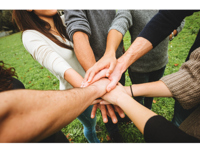 Overlapping hands in the center of a group.
