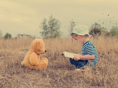 Child reading to a teddy bear